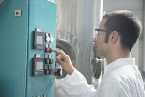 Chemist in a technical room pushing a button